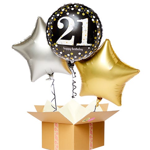A 21st birthday balloon bouquet featuring a silver and gold star balloon either side of a black 21st birthday balloon popping out of a brown cardboard box