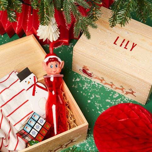 wooden personalised christmas eve box underneath a christmas tree